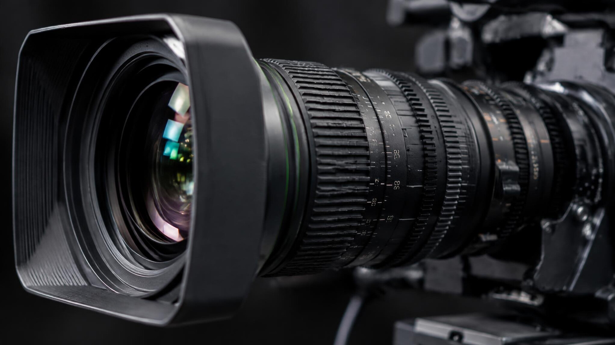 Close-up of a professional broadcast camera lens with focus rings
